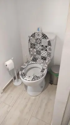 a bathroom with a toilet with a black and white seat at Au Petit Luberon in Cheval-Blanc