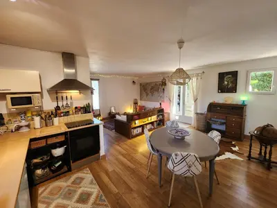 a living room with a table and a kitchen at Le Mazet des Beaujots in Monteux