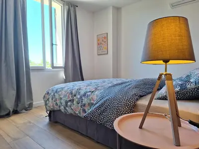 a bedroom with a bed and a table with a lamp at Mas Les Figuières in Monteux