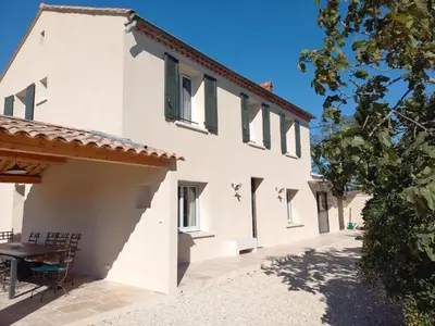 an exterior view of a white house with a table at Mas Les Figuières in Monteux