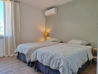 a bedroom with two beds and a window at Mas Les Figuières in Monteux