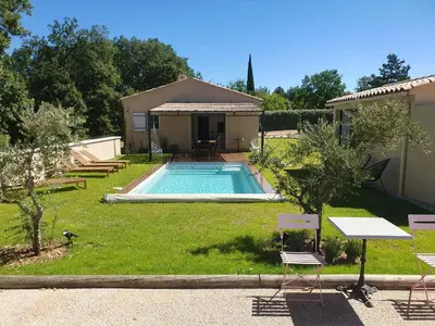 a backyard with a swimming pool and a house at La Villa Sable en Provence in Saint-Saturnin-les-Apt