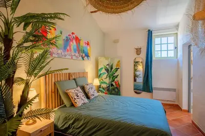 a bedroom with a bed and a plant in it at Ancien Moulin avec piscine proche Isle-sur-Sorgue in Le Thor