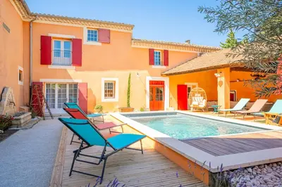 a house with a swimming pool and chairs next to it at Ancien Moulin avec piscine proche Isle-sur-Sorgue in Le Thor