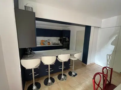 a kitchen with a counter and four stools at Bastide de la Couloubre in Mallemort