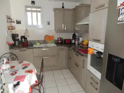 a kitchen with wooden cabinets and a table and a table and a table at Villa au calme in Eyguières