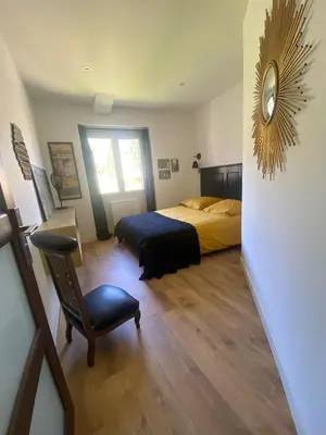 a bedroom with a bed and a clock on the wall at Chambre 2 dans Mas chez Sofi in Maubec