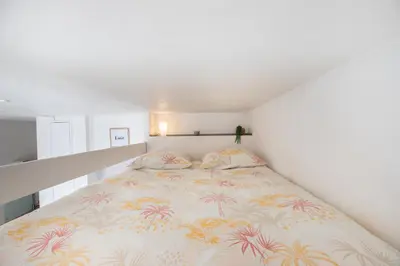a bedroom with a large bed with a colorful blanket at Le Partage des eaux - 4 couchages - Hypercentre - Clim - Wifi in LʼIsle-sur-la-Sorgue