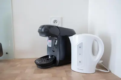 a coffee machine and a toilet in a room at Le Partage des eaux - 4 couchages - Hypercentre - Clim - Wifi in LʼIsle-sur-la-Sorgue