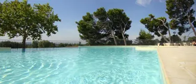 a large pool of blue water with trees in the background at Gîte Confortable Vue Exceptionnelle - Golf de Saumane in Saumane-de-Vaucluse