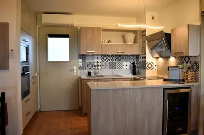 a kitchen with wooden cabinets and a counter top at Gîte Confortable Vue Exceptionnelle - Golf de Saumane in Saumane-de-Vaucluse