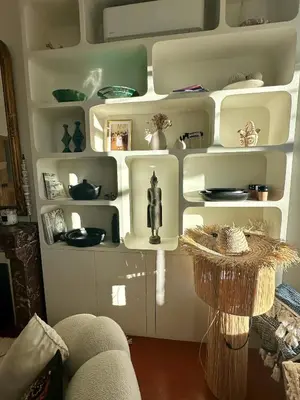 a white shelf with dishes and a statue on it at Divine Idylle Luxe 3 chambres, terrasse 130m2, jacuzzi, Clim 5 m Cours Mirabeau in Aix-en-Provence