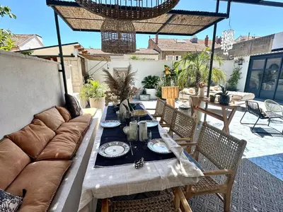 a couch and a table on a patio at Divine Idylle Luxe 3 chambres, terrasse 130m2, jacuzzi, Clim 5 m Cours Mirabeau in Aix-en-Provence