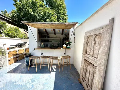 a patio with a table and chairs next to a wall at Divine Idylle Luxe 3 chambres, terrasse 130m2, jacuzzi, Clim 5 m Cours Mirabeau in Aix-en-Provence
