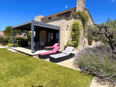 a garden with two chairs and a gazebo at Le Clos de Yann in Gordes