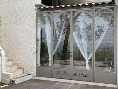 an entrance to a house with a door with curtains at Villa Le Mas des Roches à 15mn airport Marseille in Velaux