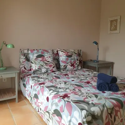 a bedroom with a bed with a flowered bedspread at les couleurs du sud in Aix-en-Provence