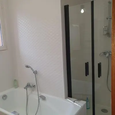 a bathroom with a shower and a white bath tub at les couleurs du sud in Aix-en-Provence