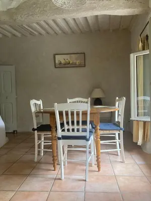 a dining room table with four chairs and a table at gîte à Rustrel in Rustrel