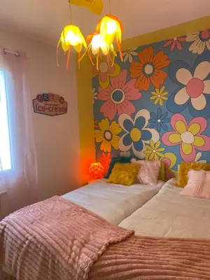 two beds in a room with flowers on the wall at Inspiration maison entière avec jardin in Pernes-les-Fontaines