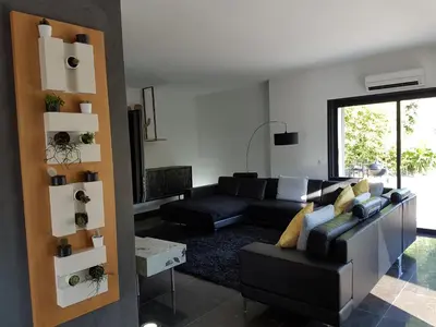 a living room with a black couch and a table at Menerbes Luberon maison moderne clim piscine in Ménerbes