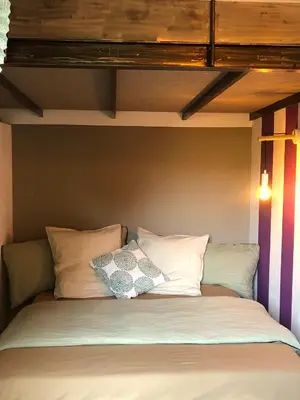 a bed with two pillows on top of it at Menerbes Luberon maison moderne clim piscine in Ménerbes