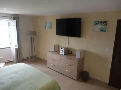 a bedroom with a bed and a television on the wall at Chambres d'hôtes L'Amphitryon 5 CHAMBRES in Villemus