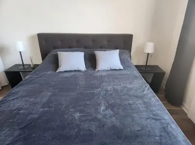 a bed with two pillows on it with two tables at L'Apt Tropez in Apt