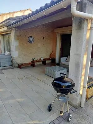a barbecue grill on a cart on a patio at petite maison avec jardin calme in Le Thor