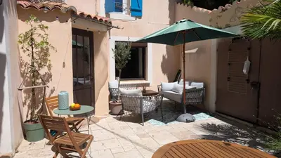 a patio with a table and an umbrella at Charming & medieval village house completely renovated with great exterior and views in Mallemort