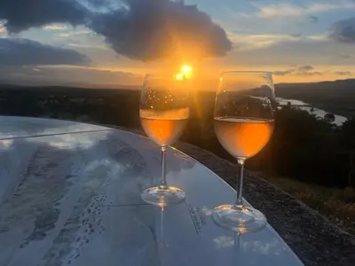 two glasses of wine sitting on a table with the sunset at Charming & medieval village house completely renovated with great exterior and views in Mallemort