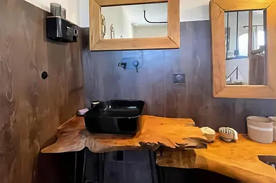 a kitchen counter with a sink and a mirror at Là où le Ciel est né Beau mas pierres et contemporain sur grande propriété vue Mont Ventoux dentelles de Montmirail in Blauvac