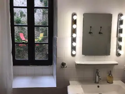 a bathroom with a sink and a mirror and a window at La Maison Joly in Ménerbes