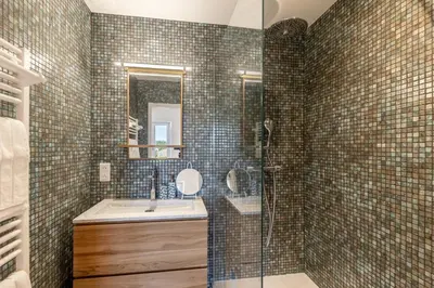 a bathroom with a shower and a sink and a mirror at Oasis de Gordes in Gordes