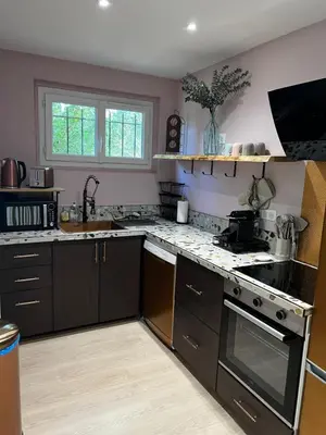 a kitchen with black cabinets and a stove top oven at Gîte de charme pour 6 personnes à Apt in Apt