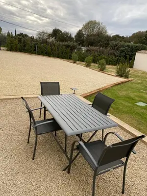 a picnic table and two chairs in a yard at Le jardin de Vaumartin in Meyrargues