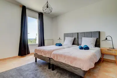 a bedroom with a large bed with blue shoes on it at Les Hauts de Provence - Maison avec piscine in Aix-en-Provence