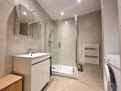 a bathroom with a shower and a sink and a washing machine at Studio centre historique 2 in Aix-en-Provence