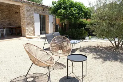 a group of chairs and tables in a yard at Air-conditioned villa with private pool overlooking Roussillon - Luberon - 8 people. in Roussillon