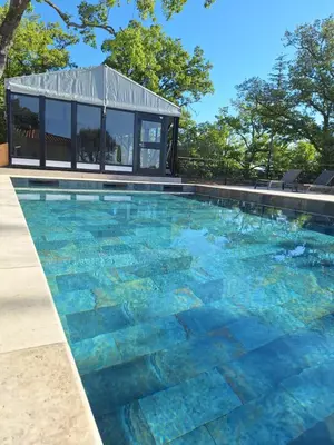 a swimming pool with a building in the background at Domaine de la Mautanne in Sainte-Tulle