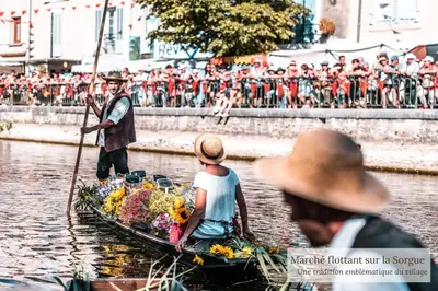 a man and a woman on a boat in the water at La Maison Bleue in LʼIsle-sur-la-Sorgue