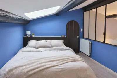 a bedroom with blue walls and a large bed at La Maison Bleue in LʼIsle-sur-la-Sorgue
