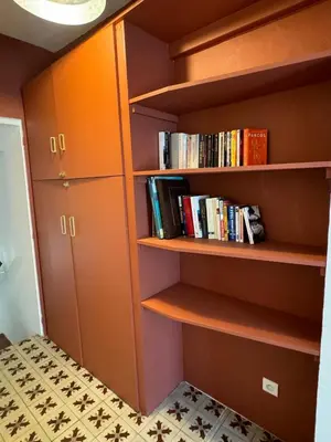 a book shelf with books on it in a room at Maison Jasmin in the city center with parking space and terrace in LʼIsle-sur-la-Sorgue