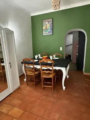 a dining room with a table and chairs and a mirror at Maison Jasmin in the city center with parking space and terrace in LʼIsle-sur-la-Sorgue