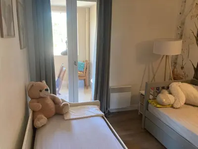 a teddy bear sitting on a bed in a bedroom at appartement T3 golf in Mallemort