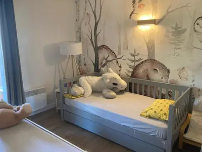 a baby room with a crib with a teddy bear at appartement T3 golf in Mallemort