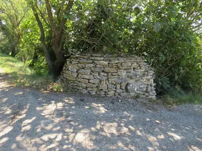 a stone wall next to a tree on a road at Maison face au Luberon avec piscine - 5 Chambres in Cabrières-dʼAvignon