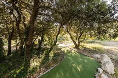 a path through a park with trees and green grass at Village Pont Royal en Provence - maeva Home - Appartement moderne et climatisé 2 pièces 4 personnes - Prestige - super Home MAE-0581 in Mallemort