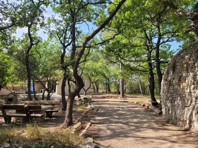 a park with benches and trees and a stone wall at Borie en Provence in Velleron