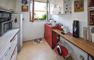 a small kitchen with a counter and a refrigerator at Nice Apartment In L'isle-Sur-La-Sorgue in LʼIsle-sur-la-Sorgue